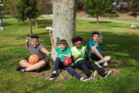 kids sitting at base of a tree